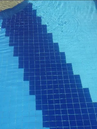 Depois: a mesma faixa de pastilha azul-escura, com a água limpa e transparente